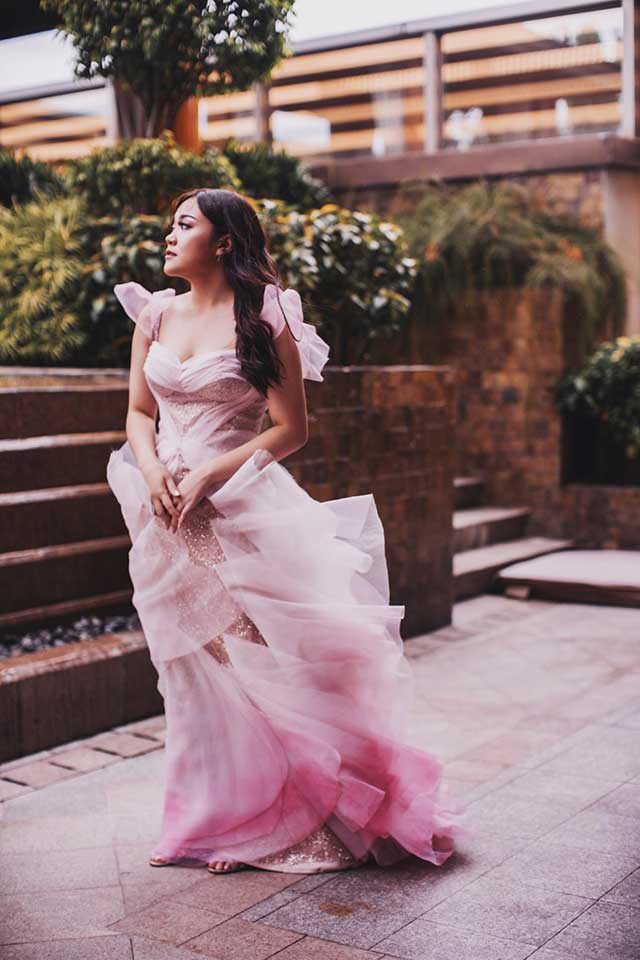 Alyanna Gopez poses outdoors in a flowing pink gown with ruffled layers during the Spouses Gopez’s Harry Potter‑themed celebration